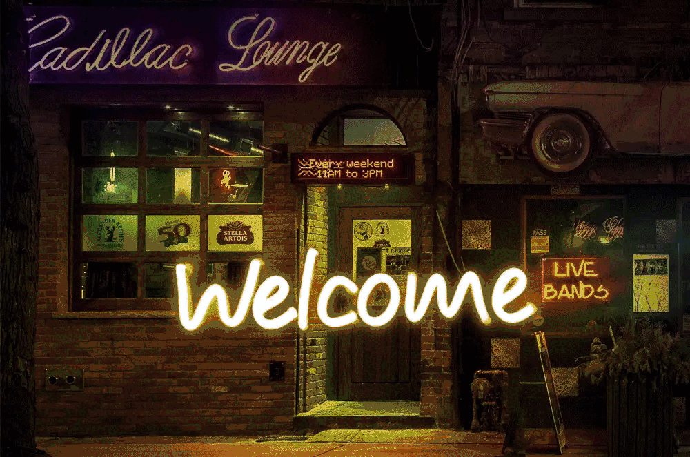 Welcome neon sign in front of storefront
